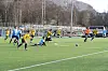 Fotballkamp på kunstgras der gule og lyseblå spelarar kjempar om ballen
